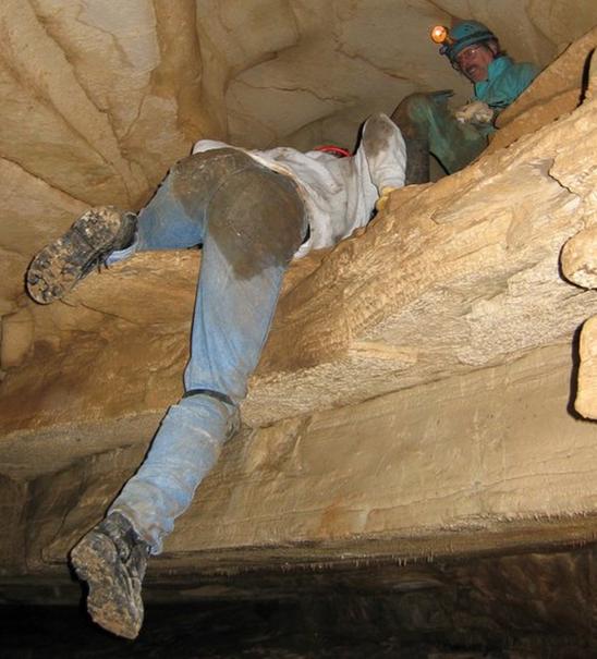 Photo from below of two cavers ascending a passage