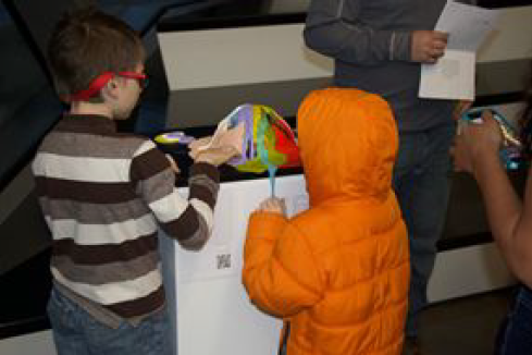 Two children touching artwork.